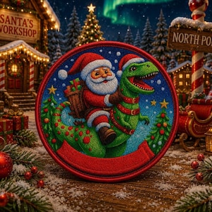 May include: A circular embroidered patch featuring a colorful illustration of Santa Claus riding a green Tyrannosaurus Rex. Santa wears a red suit and hat, carrying a brown gift basket. The background shows a snowy North Pole scene with a workshop.