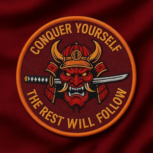 Könnte beinhalten: Gestickter Aufnäher mit einer roten Samurai-Maske und einem Katana. Der Text "CONQUER YOURSELF THE REST WILL FOLLOW" ist in Orange auf burgunderrotem Hintergrund mit einem orangefarbenen Rand. Rundes Design.