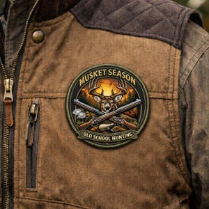 May include: A brown jacket with a "Musket Season" patch featuring a deer, crossed rifles, and the text "Old School Hunting." The jacket has a quilted shoulder detail and a zipper closure.