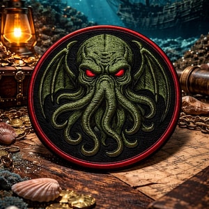 Puede incluir: Parche bordado con un diseño de Cthulhu verde, ojos rojos y alas, sobre un fondo negro con borde rojo. El parche está sobre una superficie de madera con elementos náuticos como conchas, monedas y un cofre del tesoro.