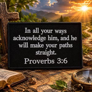 May include: A rectangular black patch featuring white embroidered text that reads: In all your ways acknowledge him, and he will make your paths straight. Proverbs 3:6. The patch has a stitched border and is displayed in a landscape orientation.