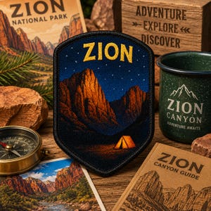 May include: A shield-shaped embroidered patch featuring a night scene of Zion National Park. The design displays dark blue mountains under a starry sky, with the word ZION in yellow at the top and a small orange tent illuminated at the base.