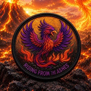 May include: A circular embroidered patch featuring a phoenix with purple and orange wings, surrounded by orange flames. The text RISING FROM THE ASHES is stitched in purple along the bottom edge of the patch, which has a thick black border.