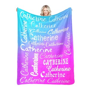 May include: A soft, pink and blue ombre fleece blanket with the name "Catherine" repeated in white text throughout the design.