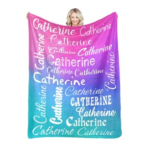 May include: A soft, blue and pink ombre fleece blanket with the name "Catherine" repeated in white text throughout the design.