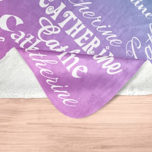 May include: A purple and blue ombre fleece blanket with the text "Gather at the riverine" in white cursive lettering.