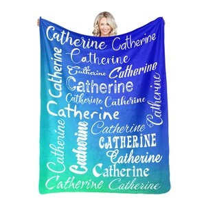 May include: A blue and green ombre fleece blanket with the name "Catherine" repeated in white cursive lettering.