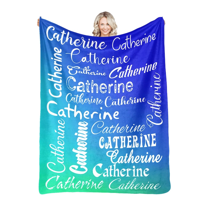 May include: A blue and green ombre fleece blanket with the name "Catherine" repeated in white cursive lettering.