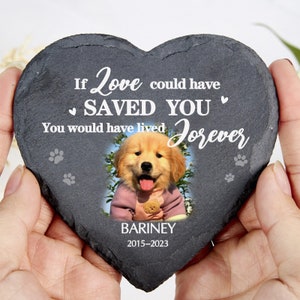 May include: Heart-shaped slate memorial stone featuring a golden retriever puppy photo. Text reads: "If Love could have SAVED YOU, You would have lived Forever." The puppy's name, "BARINEY," and the years "2015-2023" are also displayed. Paw prints are also visible.