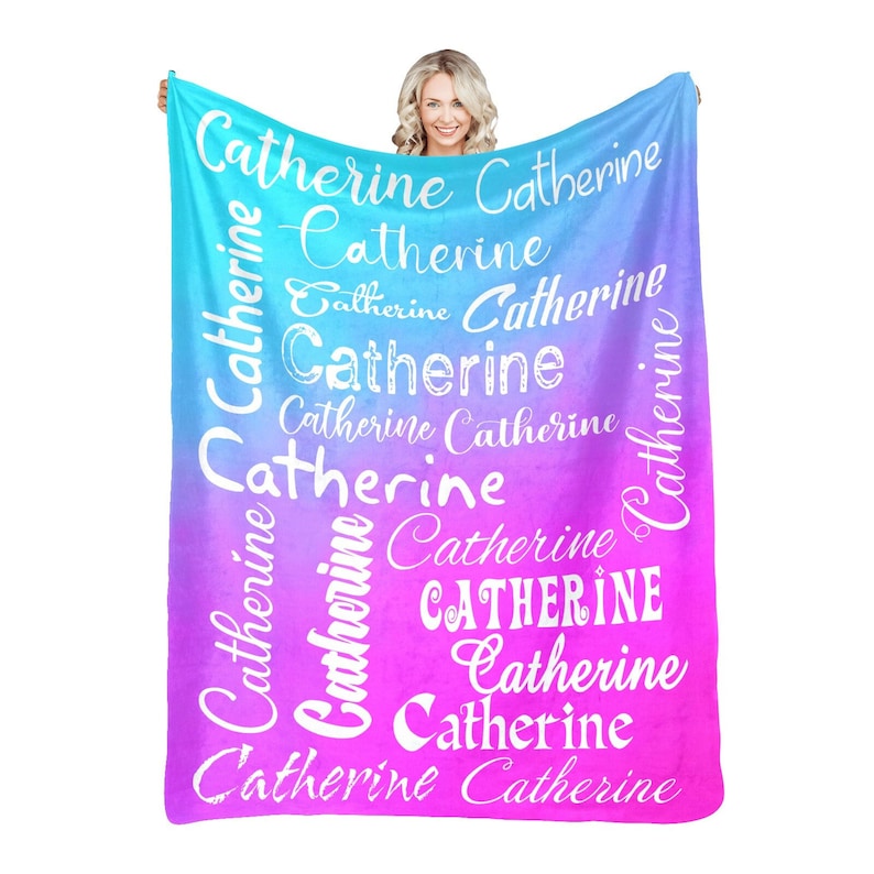 May include: A soft, pink and blue ombre fleece blanket with the name "Catherine" repeated in white text throughout the design.