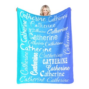 May include: A blue and turquoise ombre fleece blanket with the name "Catherine" repeated in white text throughout the design.