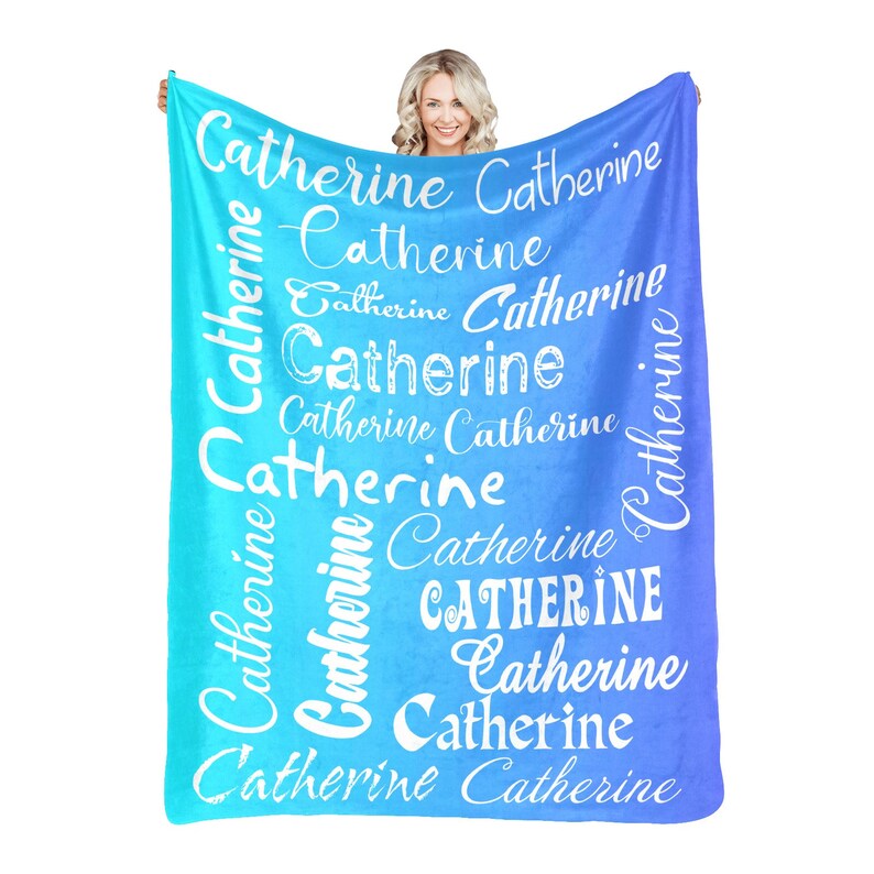 May include: A blue and turquoise ombre fleece blanket with the name "Catherine" repeated in white text throughout the design.