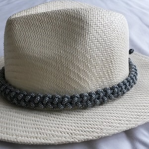 May include: A white straw hat with a black braided band around the crown.