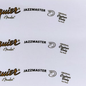 May include: Three guitar headstock decals with the Squier by Fender logo, Jazzmaster text, and Fender Custom Shop Limited Edition text.