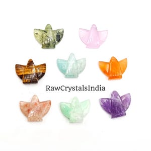 May include: Eight small angel-shaped carvings made from various polished gemstones, including tiger's eye, amethyst, and quartz, arranged in a grid with the text RawCrystalsIndia centered below the top row.