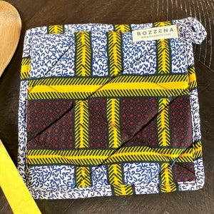 May include: A yellow, black, white, and red quilted hot pad with a "BOZZENA" label and the website address "www.bozzena.com".
