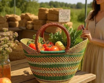 Puede incluir: Una cesta tejida con un asa de cuero marrón, llena de tomates frescos, maíz y verduras de hoja verde. La cesta tiene un patrón de rayas verdes y beige. La escena está ambientada en un mercado de agricultores, con una mujer con un vestido cerca.