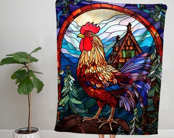 May include: A stained glass style tapestry featuring a rooster with a red comb and wattle, a blue tail, and a brown body. The rooster is standing on a rock in front of a small house with a green roof and a blue sky with clouds.