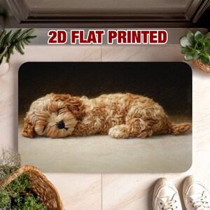 May include: A rectangular doormat featuring a sleeping, light brown, fluffy dog. The mat has a dark background and the text "2D FLAT PRINTED" at the top. White sneakers are visible on the right side of the image.