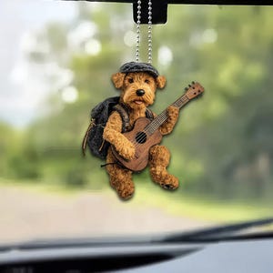 May include: A brown and tan dog wearing a black and grey hat and a brown backpack plays a brown acoustic guitar. The dog is hanging from a silver chain.