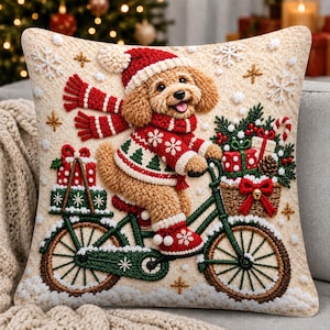 May include: A square throw pillow featuring a textured illustration of a golden puppy wearing a red and white knit hat, scarf, and sweater, riding a green bicycle. The puppy carries gift boxes and a basket of presents amidst white snowflakes.
