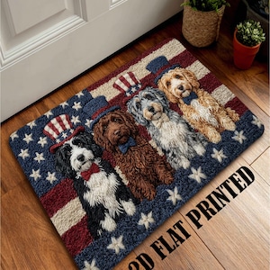 Puede incluir: Felpudo rectangular con cuatro perros con sombreros patrióticos y pajaritas, sobre un fondo de la bandera americana. La alfombra tiene una combinación de colores azul, rojo y blanco con patrones de estrellas y rayas. El texto "2D FLAT PRINTED" está impreso.