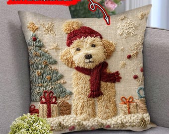 May include: Embroidered decorative pillow featuring a tan dog wearing a red hat and scarf, standing in a snowy scene with a Christmas tree and wrapped gifts. The pillow has a neutral background and the text "NOT EMBROIDERED".