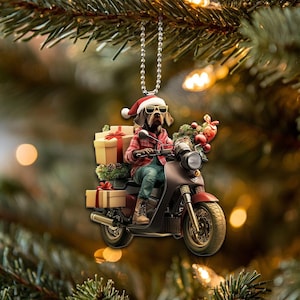 May include: A Christmas bauble depicting a dog wearing a Santa hat and sunglasses, riding a scooter with a stack of wrapped presents. The bauble is suspended from a silver chain.