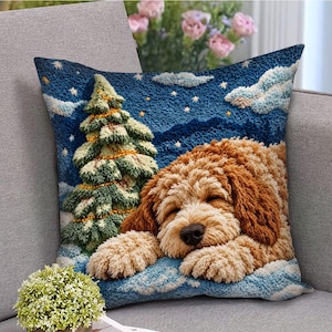 May include: A square throw pillow featuring a textured, tufted-style design of a golden-brown curly-haired dog sleeping in the snow. Beside the dog is a green Christmas tree decorated with yellow lights against a dark blue starry night sky.