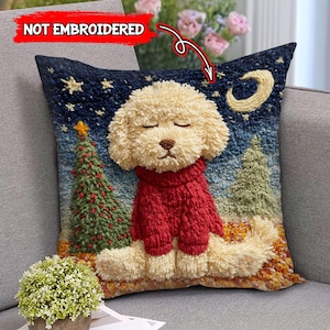 May include: A decorative pillow featuring a beige dog wearing a red sweater, set against a night sky with stars, a crescent moon, and Christmas trees. The pillow has a textured, embroidered appearance.