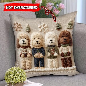 May include: Beige decorative pillow featuring four embroidered poodle figures, each holding a cup. The poodles are wearing sweaters and standing in a snowy scene with snowflakes and trees. The text "NOT EMBROIDERED" is visible.