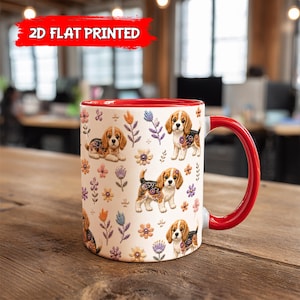 Puede incluir: Una taza de cerámica blanca con interior y asa rojos, con un patrón repetitivo de cachorros beagle y flores de estilo bordado. El texto 2D FLAT PRINTED aparece en blanco sobre un fondo rojo en la parte superior de la imagen.