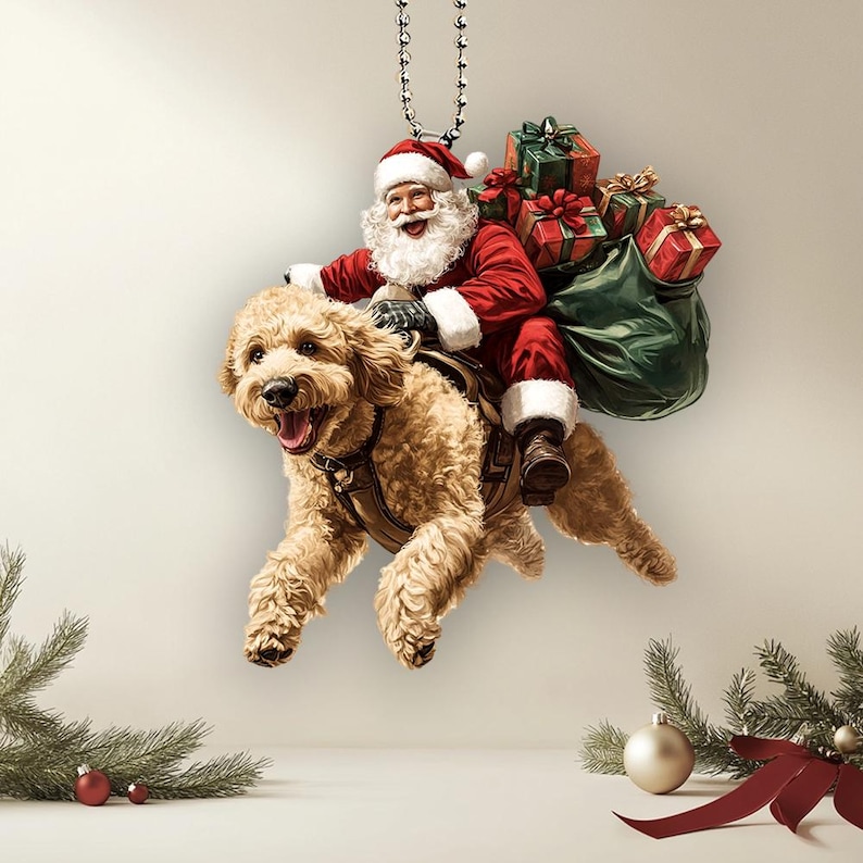 May include: A Christmas ornament featuring Santa Claus riding a golden doodle dog, carrying a bag of presents. The ornament is hanging from a silver chain.