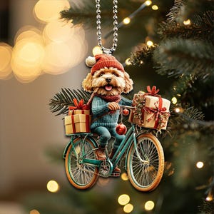 Op de afbeelding: Een bruine en witte hond met een rode kerstmanmuts en een blauwe trui rijdt op een groene fiets met een rode bel en een mand met ingepakte cadeaus. De fiets heeft een bruin zadel en een bruin stuur.