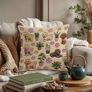 May include: A square throw pillow with a cream-colored background featuring an embroidered pattern of various brown poodles wearing sweaters, interspersed with potted green plants and small colorful flowers in shades of pink, purple, and yellow.