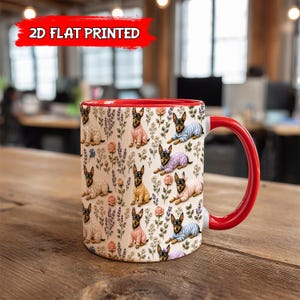 May include: A ceramic mug with a red interior and handle, featuring a repeating pattern of dogs in sweaters and floral elements. The mug has the text "2D FLAT PRINTED" in a red banner.