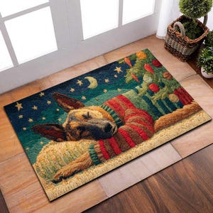 May include: Rectangular doormat featuring a sleeping German Shepherd dog wearing a red and green sweater, nestled near a Christmas tree. The background depicts a starry night with a crescent moon. The mat is made of a textured material.