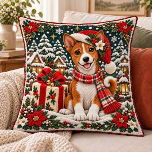 May include: A square decorative pillow featuring a textured, embroidered-style illustration of a brown and white dog wearing a red Santa hat and a plaid scarf. The scene includes a gift box, snowy pine trees, houses, and poinsettias.