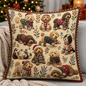 May include: A square throw pillow with a cream-colored background featuring a repeating pattern of ten goldendoodle dogs wearing festive holiday sweaters, scarves, and hats, interspersed with small floral sprigs and a red and green border.