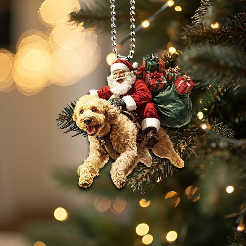May include: A Christmas ornament featuring a Santa Claus riding a golden doodle dog. Santa is wearing a red suit with white trim and a white beard. The dog is wearing a red and white saddle. The ornament is hanging from a silver chain.