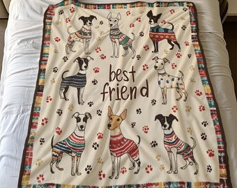 Könnte beinhalten: Eine weiße Fleece-Decke mit braunem Rand und einem sich wiederholenden Muster aus Pfotenabdrücken und Hunden in verschiedenen Posen. Die Hunde tragen bunte Pullover und der Text "best friend" ist in der Mitte der Decke gedruckt.