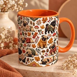 May include: A ceramic mug with a bright orange interior and handle, featuring a repeating pattern of pugs wearing sweaters, surrounded by autumn leaves, acorns, pinecones, and mushrooms on a white background. The design includes various pug poses.