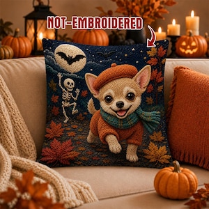 May include: A square throw pillow featuring a tan chihuahua wearing an orange sweater, a beret, and a teal scarf. The background shows a night scene with a full moon, a dancing skeleton, and autumn leaves. The text NOT-EMBROIDERED is printed at the top.