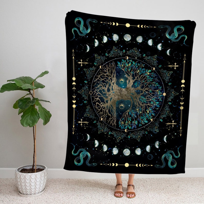Puede incluir: Un tapiz negro con un dise&ntilde;o de &aacute;rbol de la vida dorado. El &aacute;rbol est&aacute; rodeado por un c&iacute;rculo de lunas y estrellas. Hay dos serpientes verdes a cada lado del &aacute;rbol.