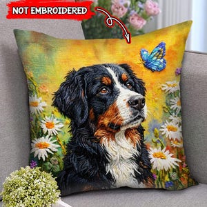 May include: Decorative throw pillow featuring a Bernese Mountain Dog with a butterfly and daisies. The pillow has a yellow background and the text "NOT EMBROIDERED". The dog has black, brown, and white fur.
