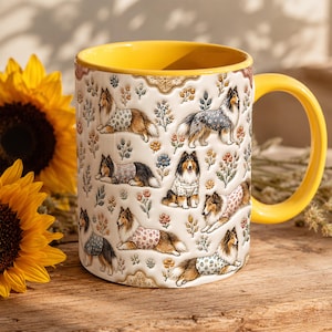 May include: A ceramic mug with a bright yellow interior and handle, featuring a repeating pattern of brown and white collie dogs wearing various floral-patterned sweaters, interspersed with small colorful botanical illustrations.