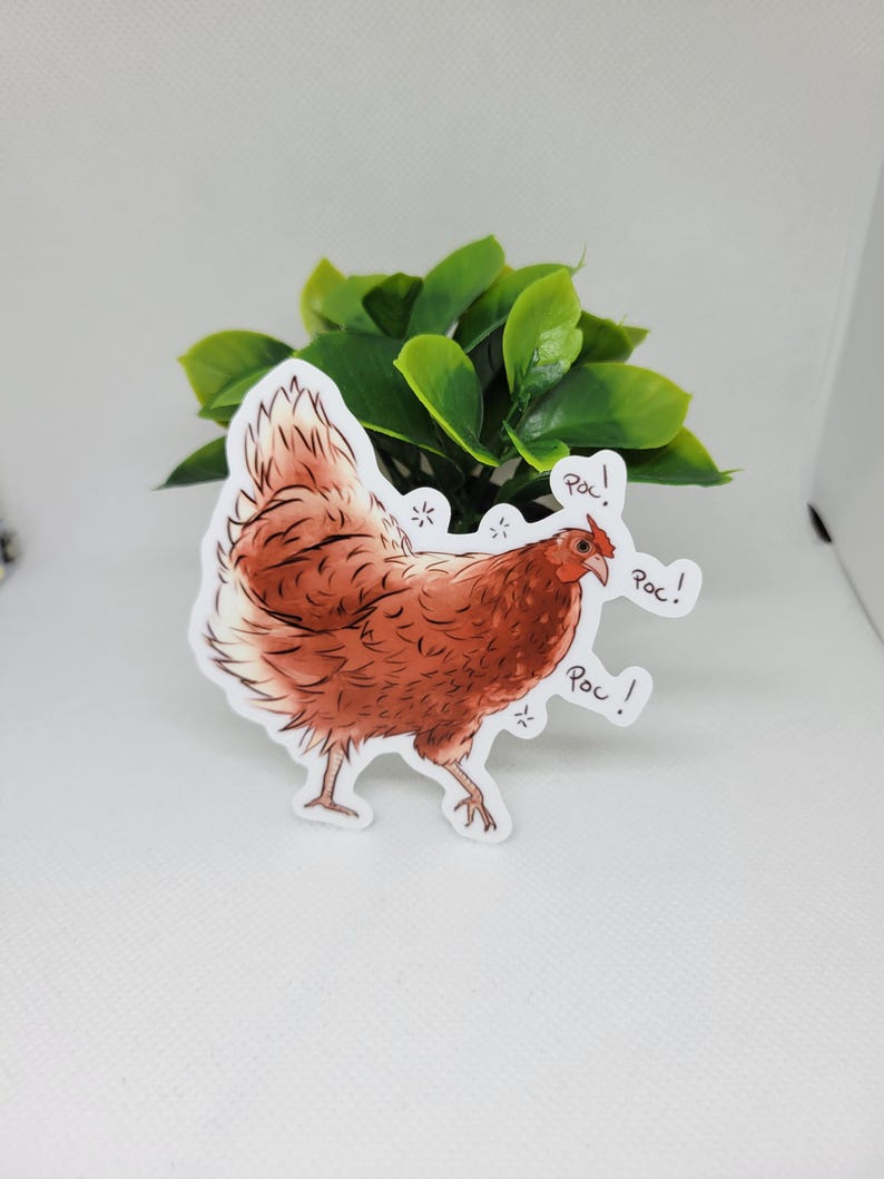 May include: A brown and white chicken sticker with the word "Roc!" repeated three times. The chicken is facing right and has a red comb and wattle.
