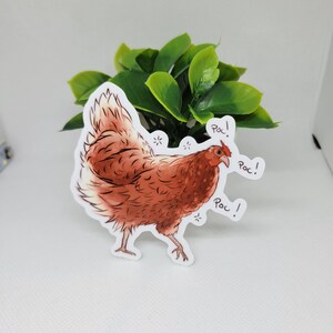 May include: A brown and white chicken sticker with the word "Roc!" written three times. The sticker is on a white background.