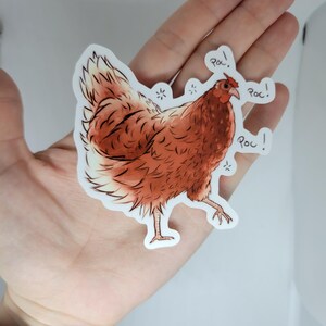 May include: A brown and white chicken sticker with the word "ROC!" written three times around it.