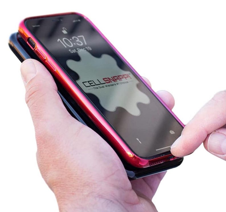 May include: A red phone case with a black phone inside. The phone case has a raised edge around the screen and a logo that says "CELL SNAPPIT - The Dust Welders of Choice".